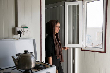 Nadia Murad, a 21 year old Yazidi woman, looks out of the window of her temporary housing unit in a refugee camp in Dohuk.  In 2014 she was kidnapped from her home by Islamic State militants and held...
