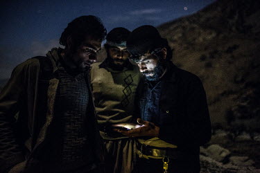 Bakhtiari nomads Mohammed Hossein and two of his brothers check for a signal on their smartphone. Eventually they managed to get a signal after walking 20 minutes away from their camp.