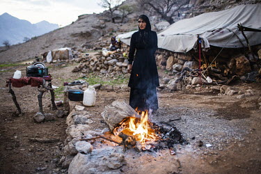 Hava (19) standing beside a fire at a Bakhtiari nomad mountain camp in Kohne ab, Arpanah. She has two children and says she is unhappy in the mountains, but unable to survive in the city so always end...
