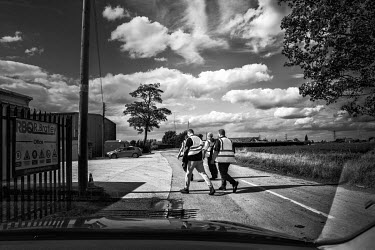 Migrant farm labourers from Bulgaria crossing between two sites of a farm in the small Fenland village of Quadringe Eaudike.