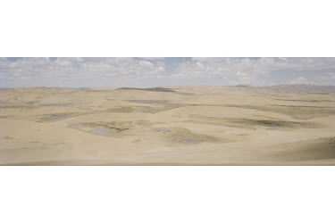 Lakes surrounded by desert in the Sanjiangyuan National Nature Reserve. The crescent shaped sand dunes mark the direction the wind blown sand has travelled, whilst small lakes that used to feed into t...