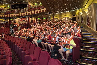 Newly boarded passengers don life jackets for a compulsory safety drill in the theatre of the MSC Musica, a cruise ship owned by the Mediterranean Shipping Company. The ship takes 2000 passengers on a...