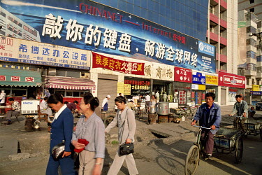 People passing a billboard advertising an internet connection supplied by Chinanet.
