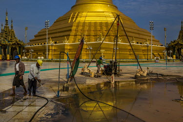 Workers reparing the floor of the Uppatasanti Pagoda, a near life-sized replica of the Shwedagon Pagoda.