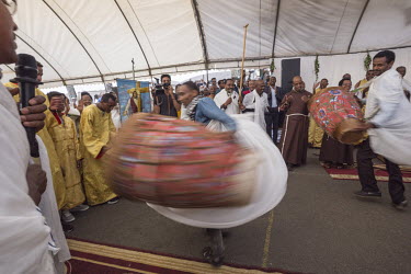 Men and women playing church drums and dance together during a special 'Saviour Service' at The Holy Saviour Catholic Church. As the church cannot accommodate all its congregation marquees have been e...