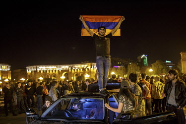 A man waves the national flag as people celebrate in Republic Square after hearing that Prime Minister Sargsyan announced his resignation following mass protests at his move from president to prime mi...