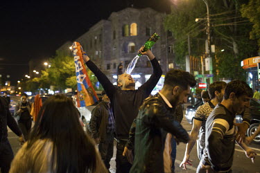 A man pours a bottle of wine over himself as people gather in Republic Square to celebrate after hearing that following mass protests at his move from president to prime minister Prime Minister Sargsy...