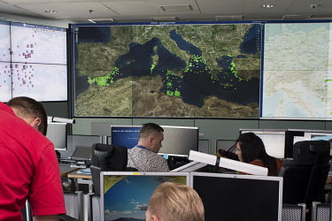 Frontex employees working in the operations room at the Frontex agency's headquarters. Here they receive data about possible breaches of the EU border, mostly boats crossing the Mediterranean Sea.