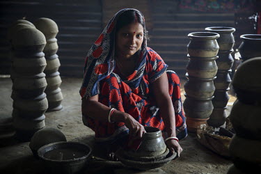 A woman making a pot at one of the many artisan pottery businesses in Dhamrai.