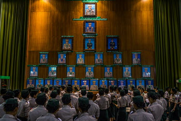 During a weekend excursion to the Defence Services Museum, a group of young cadets from the military services academy gather around a display of portraits of generals and military officials with a por...