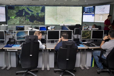 Frontex employees working in the operations room at the Frontex agency's headquarters. Here they receive data about possible breaches of the EU border, mostly boats crossing the Mediterranean Sea.