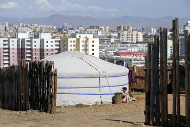 A woman sits outside a yurt on the margins of the capital. Many nomad families who move to the city looking for a new life find themselves struggling to find work and housing.