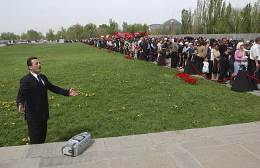 An Armenian singer records a video clip while his compatriots queue to take flowers to the Genocide Monument as they commemorate the 1915 genocide.