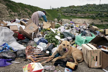 A woman searches through a rubbish tip looking for items to sell or recycle.
