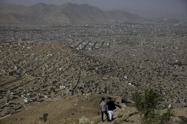 Two boys stand on Chehel Dokhtaran hill above Datche the immense Hazara sector of the capital.