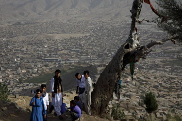 A group of men take a selfie on Chehel Dokhtaran hill above Datche the immense Hazara sector of the capital.