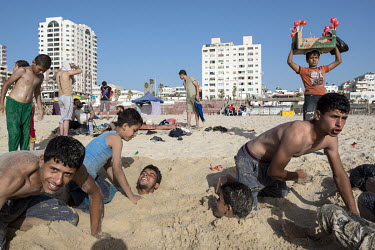 Young men playing in the sand on the beach of Gaza.