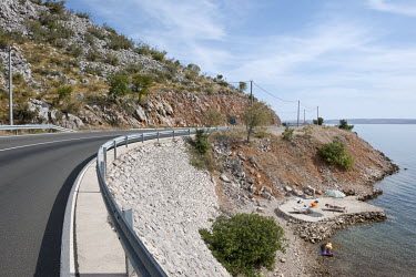 A coastal road and a concrete bathing area on the Adriatic Coast.