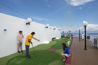 Passengers play mini golf on board of the MSC Lirica, a cruise ship belonging to the Mediterranean Shipping Company.