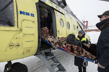 Paramedics and slight staff carry a patient onto a waiting helicopter which will fly him to the district hospital. Vladimir (name changed) (67) had a stroke in the night but due to bad weather conditi...