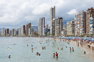 A crowded beach and highrise holiday accomodation on the Mediterranean coast.