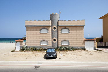 A castle-shaped seaside villa on the Mediterranean coast.
