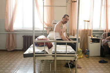 Leonid (56) siting on a bed in Turukhansk district hospital.  He arrived by helicopter from Svetlogorsk after injuring his leg.