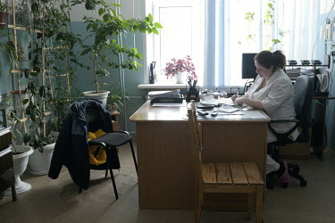 Paramedic Irina, completes paer work at her desk in Turukhansk hospital.