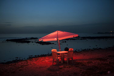 A parasol, table and chairs at a beach bar in Al-Mina.