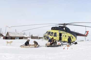 A patient, with a paramedic, are transported on a snowmobile from their house to the helicopter which will fly them to hospital.