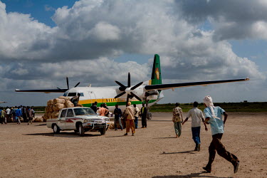 People unload hessian sacks full with khat. Each day, five planes fly in from Nairobi, stuffed with kat, and land at the private airport built by the war lord Mohamad Kanyare. From 10 am on hundreds o...