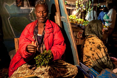 A khat trader at his stall in a khat nightmarket. The khat is imported by truck from Harrare in Ethiopia and it is a big busness, around GBP 157,000 (USD 200,000) is traded each day.