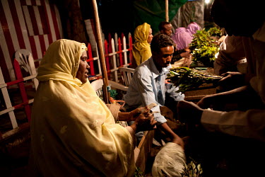 A woman holds a bunch of khat out for sale on her stall in a khat nightmarket. The khat is imported by truck from Harrare in Ethiopia and it is a big busness, around GBP 157,000 (USD 200,000) is trade...