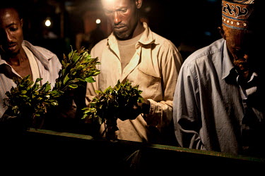 People examine bunches of khat at a stall in a khat nightmarket. The khat is imported by truck from Harrare in Ethiopia and it is a big busness, around GBP 157,000 (USD 200,000) is traded each day.