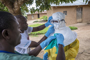 An Ebola response team help each other put on their personal protective equipment (PPE) after they arrive in Oicha, about 30 kilometres north of Beni, where they will vaccinate anyone who has been in...