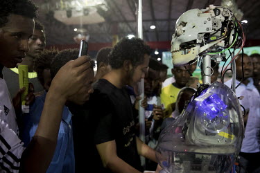 A crowd of onlookers forms around a robot manufactured by ICog-Labs a technology company working with artificial intelligence, on display at a trade fair organised by the government to celebrate its 2...