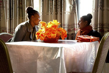 Two women sit together at a table in a hotel in the port of Gorogora on Lake Tana.