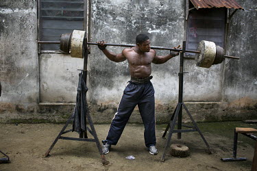 A security guard lifts weights outside on the Jakande Estate.