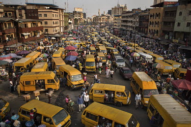 Bright yellow mini-buses drop-off and pick-up passengers at Idumota Market on Lagos Island.