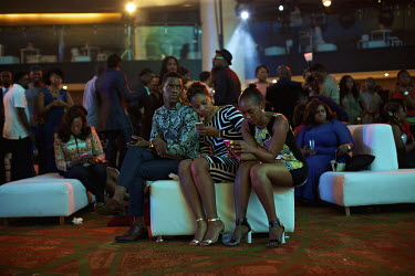 Guests checking their smartphones at the Africa Magic Viewer's Choice Award nominees pre-award party. The awards, held at Eko Hotel & Suites, celebrate African-made films.