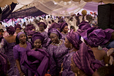 Women, all dressed in purple outfits, at the wedding party for bride and groom Gbemisola and Olumide at the Yoruba Tennis Club.