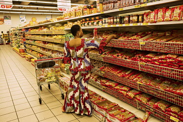 A woman selects pasta on a Saturday afternoon shopping trip to a branch of the supermarket Shoprite at the Ikeja City Mall. Lagos has a rapidly growing population of 21 million people and its booming...