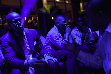 Men smoking at the Lagos Cigar Club at the Radisson Blu Hotel on Vicotria Island. Among the city's rapidly increasing population of 21 million there is a growing middle class who wish to enjoy the tra...