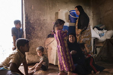 Children surround their grandmother, 59 year old widow and housewife Hameda Ziad, at their home in Al Saqalawiya. Hameda and her family lived under the occupation of so-called Islamic State (IS). Afte...