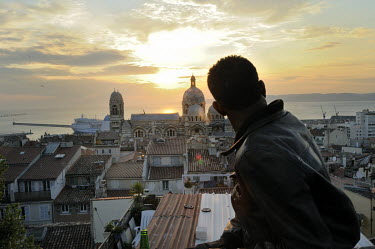 A man in Le Panier (the basket) district looks towards the city's Cathedral Major.