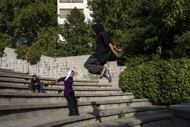 A group of teenage boys and girls, in Niavaran Park, practice Parkour, a sport using the urban landscape as an obstacle course.