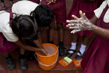 Nursery school children, on the Idulgashinna tea estate, wash their hands as they learn the importance of hygiene.