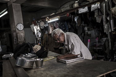 Jacques Soodeen (77) at work in his metal workshop in Chinatown. Soodeen, who was adopted by a Chinese-Mauritian family as a child, has been making metal goods in this same workshop since he was a tee...