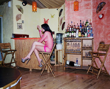 A pole dancer smokes a cigarette during a break at the Premier strip club. (Prior to the 2014 Russian occupation)
