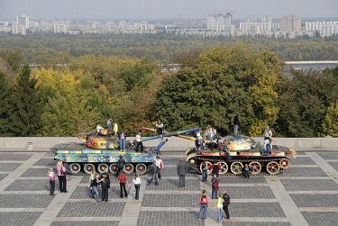 Children play on two colourfully painted tanks in front of the Museum of the Great Patriotic War.